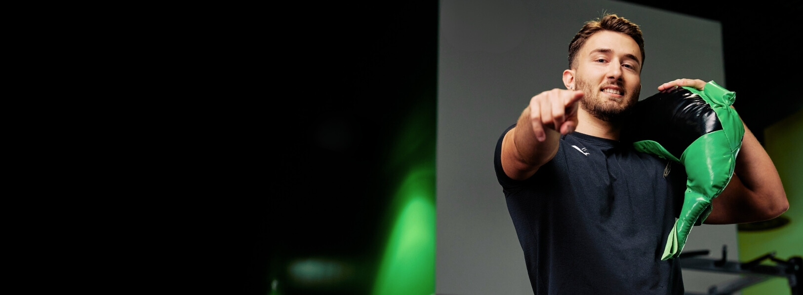 man lifting bulgarian bag and pointing in gym